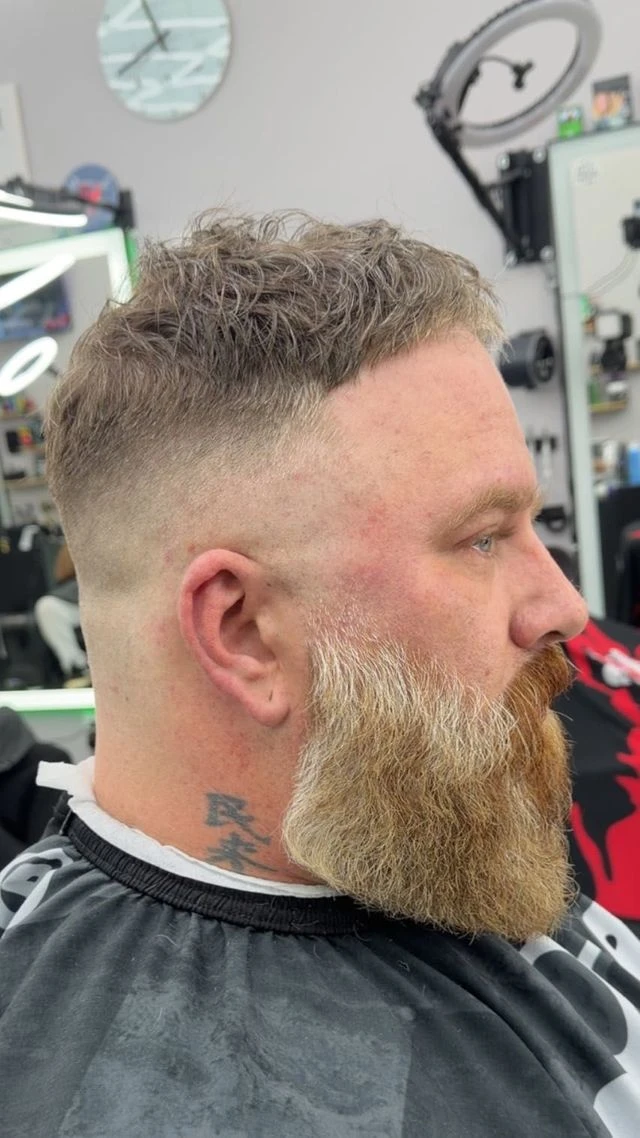 Textured haircut with faded sides and a full blond beard from Norie’s Booksy portfolio