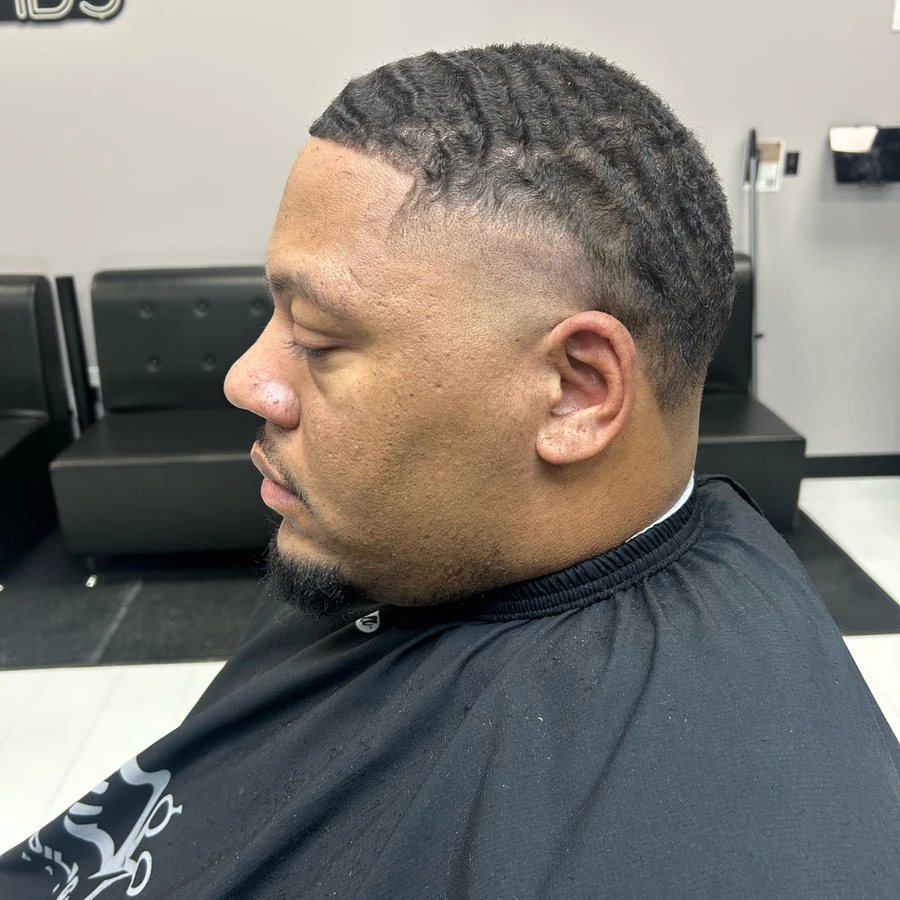 Wave haircut and tapered sides shown with the full face in profile